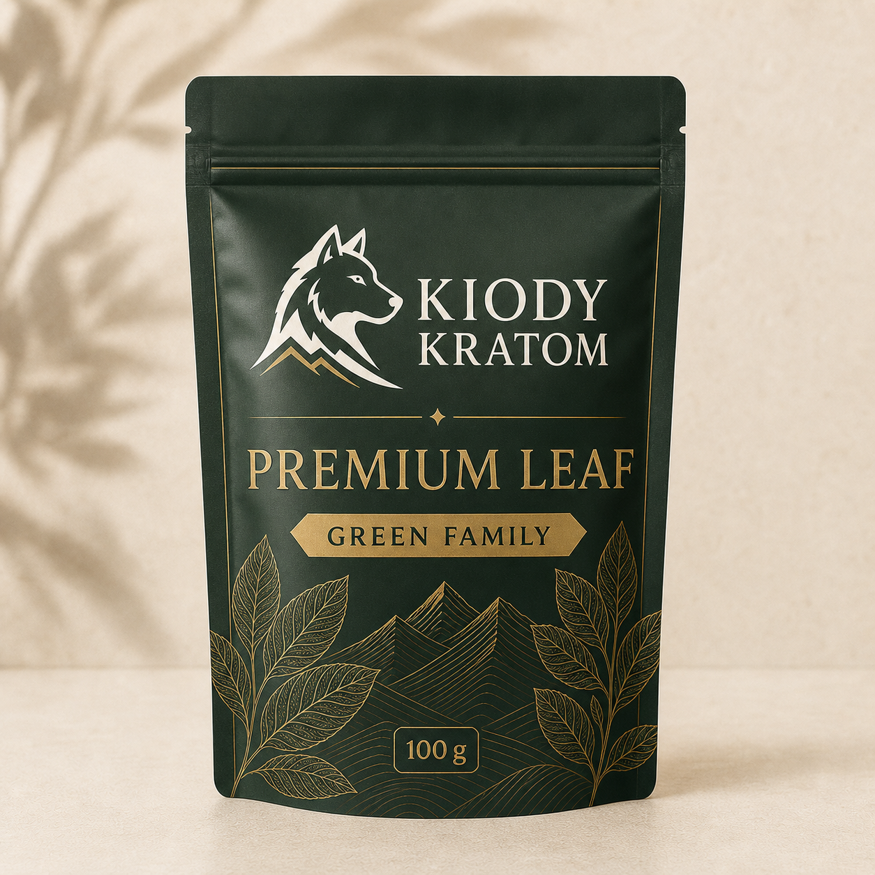 Kiody Green Family Premium Leaf kratom powder in a deep forest 100 gram pouch with gold wolf, leaves, and mountain lines