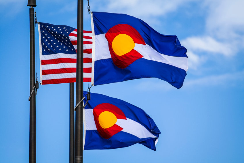Colorado and USA flags with blue sky background
