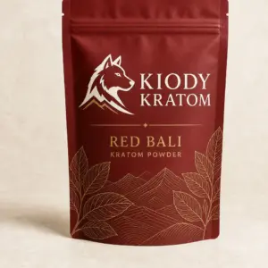 Kiody Red Bali Kratom powder in a clay-red pouch with gold botanical artwork
