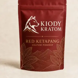 Kiody Red Ketapang Kratom powder in a clay-red pouch with gold botanical artwork