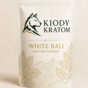 Kiody White Bali Kratom powder in a warm-ivory pouch with gold botanical artwork