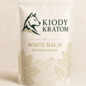 Kiody White Malay Kratom powder in a warm-ivory pouch with gold botanical artwork